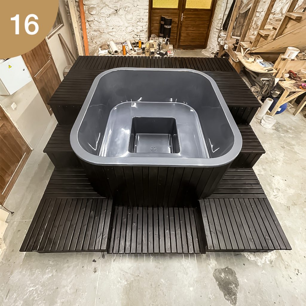 A square hot tub with a wrap-around stairs, finished with burned boards